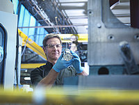 employee inspects metal part